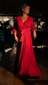 Vestido largo negro con escote en V cruzado, mangas largas y lazo en la cintura.