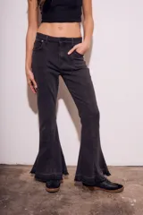 Pantalón de jean negro con corte flare, tiro medio y ruedo desflecado.