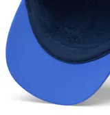 Gorra Columbia Powderkeg Ball Cap de color azul, con diseño de cinco paneles y visera plana. Presenta el logo clásico de la marca impreso en el frente en color negro y blanco.