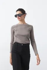 Remera de manga larga color blanco, de calce entallado, con cuello redondo a la base y costuras verticales decorativas que estilizan la silueta.