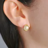 Aros tipo botón dorados con textura martillada.