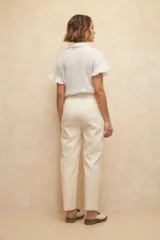 Pantalón de vestir color crema, de corte recto, con bolsillos laterales y traseros. Se ajusta a la cintura con dos botones.