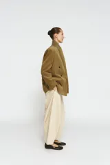 Blazer oversize de pana con cuello solapa y manga larga. Presenta cierre frontal cruzado con botones, bolsillos delanteros y forro interior a tono.