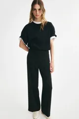 Pantalón sastrero de tiro alto y piernas amplias con pliegues en la parte delantera y trasera, en color negro.