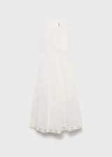 Vestido largo de algodón blanco con diseño sin mangas, cuello redondo y aberturas laterales en la cintura. Presenta un delicado bordado floral calado en la parte superior y en el ruedo, con una falda de corte evasé.
