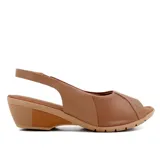 Sandalia de cuero negra con puntera abierta y talón cubierto. Cuenta con una tira trasera con hebilla y una plataforma de goma color beige con tecnología Care Juanetes.