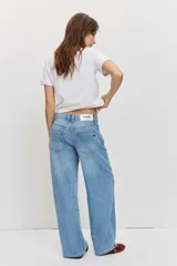 Pantalón de jean de corte regular y pierna ancha, en color celeste con lavado clásico, tiro medio y diseño de cinco bolsillos.