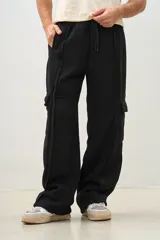 Pantalón jogger negro de corte ancho con bolsillos cargo y cordón ajustable en la cintura.