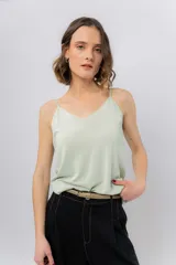 Musculosa de breteles finos con escote en V, confeccionada en tejido fluido con una leve textura satinada.
