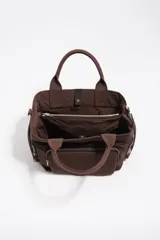 Bolso bandolera Pocket Bimba Y Lola de tamaño mediano, color tostado, confeccionado en nylon con estructura blanda, doble asa de mano y correa de tejido. Incluye un bolsillo exterior frontal con cierre y el logo metálico de la marca.