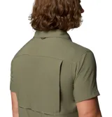 Camisa de manga corta Columbia, color verde oliva, con cuello clásico, cierre frontal de botones y dos bolsillos frontales en el pecho. Presenta un diseño técnico con ventilación en la espalda, ideal para actividades al aire libre.