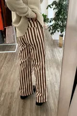 Pantalón de jean con estampado de rayas verticales marrones y blancas, de corte wide leg y tiro medio.