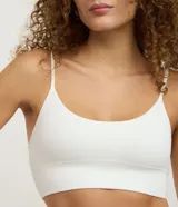 Soutien tipo top de color negro, confeccionado en tejido seamless texturizado con tirantes finos ajustables. Cuenta con copas desmontables y diseño sin costuras.