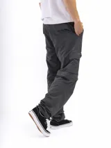 Pantalón de trekking convertible color verde militar, con piernas removibles mediante cierre a la altura de la rodilla, transformándolo en bermuda. Presenta múltiples bolsillos cargo con tapa y cierre, y cintura con pasadores para cinturón.