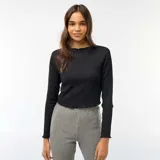 Camiseta corta de manga larga en tejido texturizado tipo crepé de color negro, con cuello redondo y terminaciones con sutil relieve ondulado en cuello, puños y ruedo.