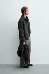 Sobrecamisa de corte relajado confeccionada en tejido con textura efecto pelo. Presenta diseño de cuadros en tonos verde y negro, cuello solapa, cierre frontal con botones, manga larga con puños abotonados y un bolsillo de plastrón en el pecho.