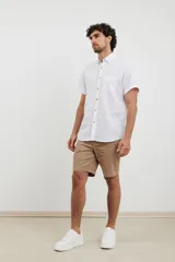 Camisa azul de manga corta, con cuello abotonado y bolsillo en el pecho.