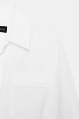 Vestido midi de estilo camisero color marrón, con cuello solapa, escote en pico y cierre frontal con botones. Presenta mangas largas, bolsillos laterales ocultos, solapas decorativas en el pecho y cinturón de lazada en el mismo tejido.