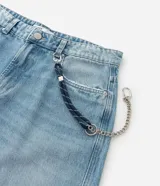 Pantalón de jean modelo skater, de corte holgado y tiro medio, con diseño de cinco bolsillos y detalle de cordón decorativo en la cintura.