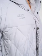 Parka larga Umbro color gris claro, acolchada con diseño de rombos y capucha.