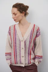 Cardigan de punto con escote en V y cierre frontal de botones. Presenta un diseño estampado con patrones geométricos en tonos beige, marrón y detalles en azul vibrante.