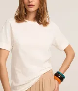 Remera básica de manga corta con vuelta en los puños, cuello redondo y corte recto, de color blanco.