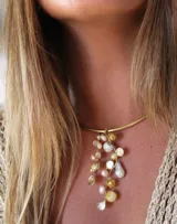 Gargantilla rígida dorada con colgante de perlas irregulares y cuentas doradas.