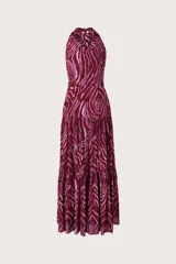 Vestido largo con escote halter y espalda descubierta, confeccionado en tela fluida con estampado animal print en tonos bordó y rosado. Presenta un corte entallado en la cintura y falda con volados escalonados.