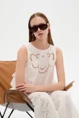 Musculosa de algodón blanca con cuello redondo y diseño holgado, con detalles de bordado y broderie perforado en el frente.