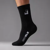 Medias negras de caña alta con diseño acanalado, elástico superior y detalles estampados en blanco que incluyen el logo en el empeine y el lateral.