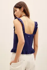 Top de punto color azul marino, con tirantes anchos con volados, escote cuadrado y cierre frontal con botones. Presenta un diseño ajustado con detalles de volados en el ruedo.
