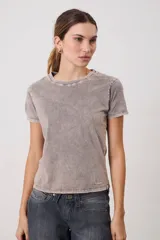 Remera de manga corta con cuello redondo y calce ajustado, confeccionada en algodón con un acabado lavado tipo acid wash en tono gris.