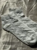 Medias blancas de tejido texturizado con rombos en relieve y borde superior con volados.