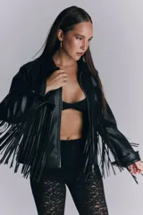 Campera de cuero sintético negro con flecos largos en la espalda y mangas. Presenta un diseño de estrellas pespunteadas en la parte superior de la espalda.