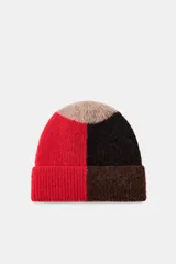 Gorro tipo beanie de punto con diseño de bloques de color en tonos rojo, negro y beige. Presenta un acabado con vuelta y textura suave.