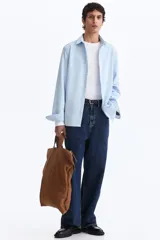 Camisa de manga larga en tejido elástico de mezcla de algodón, con cuello italiano, cierre frontal de botones y puños ajustables. Presenta un corte entallado slim fit y bajo redondeado.