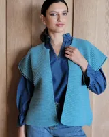 Chaleco tejido de punto color lila, sin mangas y con cuello abierto.