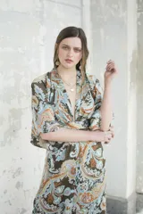 Kimono largo con estampado paisley en tonos marrones, celestes y naranjas. Tiene mangas 3/4 amplias y corte cruzado con lazo en la cintura.