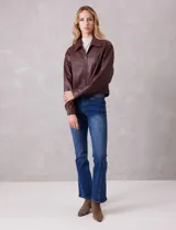 Campera de eco cuero color bordó, con cuello camisero, cierre frontal metálico y bolsillos laterales. Presenta un diseño de corte recto y forro interno a tono.