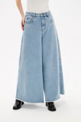 Pantalon de jean azul de corte ancho y tiro alto, con ruedo deshilachado.