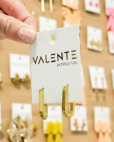 Aros tipo argolla de diseño rectangular alargado, con acabado en tono dorado.