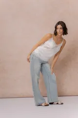 Jean wide leg tiro alto de lavado claro, con diseño de cinco bolsillos, cierre frontal con botón y aplicación de strass en degradé a lo largo de los laterales.