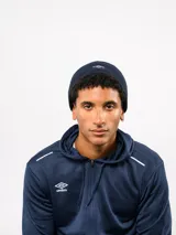 Gorro tipo beanie de Umbro, confeccionado en tejido polar negro, con el logo de la marca bordado en blanco en la parte frontal.