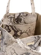 Cartera tipo tote bag plateada, con doble asa corta y correa de cadena extraíble.