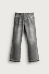 Jeans flare fit de denim de algodón color gris con lavado efecto desgastado. Presentan diseño de tiro medio, ajuste en la parte superior y apertura en campana desde la rodilla, con cinco bolsillos, cierre frontal con cremallera y botón, y bajo con acabado irregular.