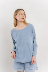 Remera manga larga color rosa con bolsillo en el pecho y corte irregular en el ruedo.