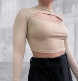 Remera blanca de tejido de punto acanalado, con cuello alto y abertura en el pecho.