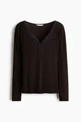 Remera de manga larga de punto acanalado color negro, con ajuste entallado y escote en V ribeteado con encaje.