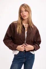 Chaqueta de efecto gamuza color marrón, con flecos en el frente y la espalda, cuello clásico y cierre frontal con botones metálicos a presión.