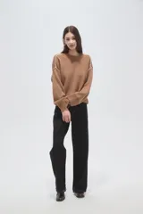Sweater de algodón color natural, de corte holgado y cuello redondo. Presenta detalles de costuras decorativas con bordado en los hombros y puños acanalados.